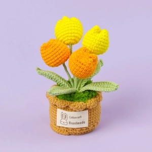 Handgefertigte gehäkelte Tulpen im Topf mit gelben und orangen Blumen und grünen Blättern