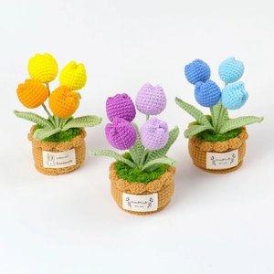 Detailansicht handgehäkelter Tulpen-Töpfe in den Farben Lila, Gelb und Blau