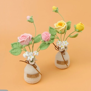 Detail von handgehäkelten Rosen in weißen Strickvasen mit Hand Made Leder-Etiketten