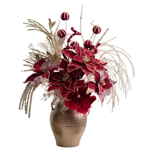 Christmas centerpiece with burgundy poinsettias and gold accents in a vintage bronze vase