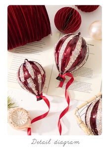 Close-up of hot air balloon Christmas ornament with red velvet ribbon and silver glitter