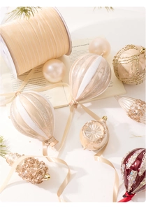 Champagne hot air balloon ornament and glitter baubles on vintage book pages for Xmas