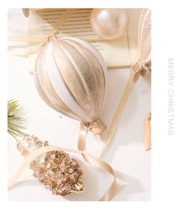 Close-up of champagne gold hot air balloon and pinecone ornaments for Christmas tree