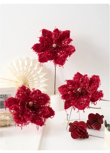 Close-up of velvet burgundy poinsettia with gold glitter for Christmas decor