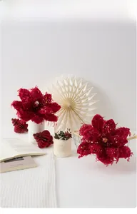 Detail of burgundy velvet Christmas poinsettia flowers in a white vase on festive table