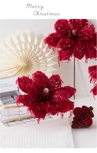 Close-up of deep red velvet Christmas flowers with glitter edges and tassel details