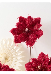 Close-up of velvet burgundy magnolia flower with gold glitter and pearls for Christmas decor
