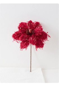 Detailed close-up of burgundy artificial Christmas flower with gold sequins and beads