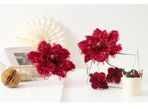 Close-up of burgundy artificial poinsettia with velvet petals and golden glitter details