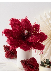 Close-up of elegant burgundy velvet artificial flower with shimmering beads in a vase