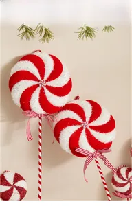 Close-up of red and white spiral lollipop tree ornament with ribbon bow and glitter finish