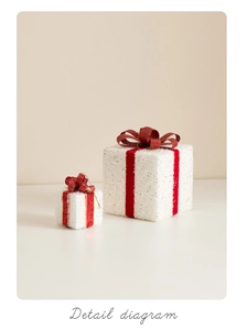 Detail of red velvet bow on white glittered Christmas gift box ornaments for tree decor