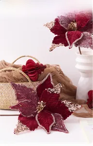 Detail of burgundy velvet Christmas poinsettia with gold glitter petals and golden center
