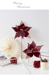 Detail view of velvet burgundy poinsettia flowers with gold glitter for Christmas decor