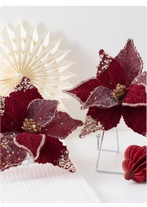 Macro detail of burgundy velvet poinsettia flowers with gold glitter and sequins