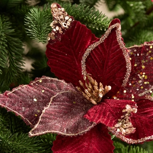 Fiore di Natale in velluto bordeaux con glitter dorati su ramo di abete