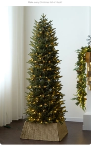 Detail of pre-lit pencil Christmas tree with warm LED lights and woven tree skirt base