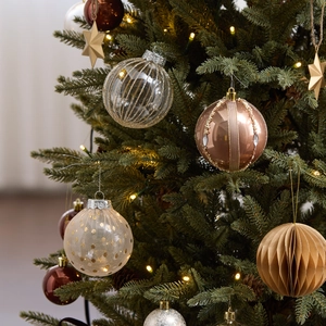 Luxurious Christmas ornaments set with champagne gold baubles on a lit Christmas tree