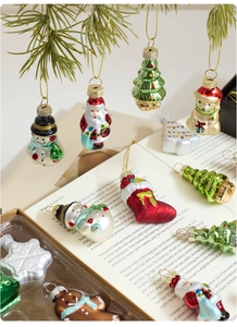 Detailed view of colorful glass Christmas ornaments hanging on a pine branch with gift box