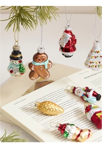 Detailed view of hand-painted glass Christmas ornaments hanging on a green pine branch