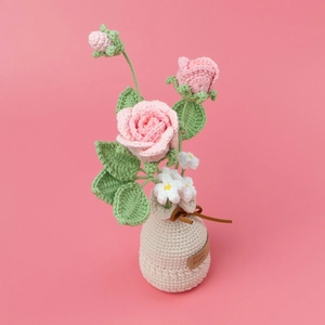 Handgefertigte rosa Häkelrosen in einem Stricktopf für stilvolle Wohndekoration