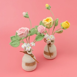 Nahaufnahme von handgehäkeltem Rosenstrauß in beige Vase mit Leder-Etikett