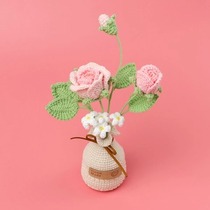 Detailansicht handgehäkelter rosa Rosen im cremefarbenen Topf mit Hand Made Etikett