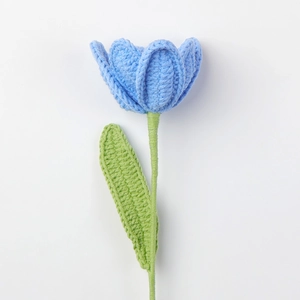Detailaufnahme von handgefertigtem Häkelstrauß mit blauen Tulpenblüten und grünen Blättern