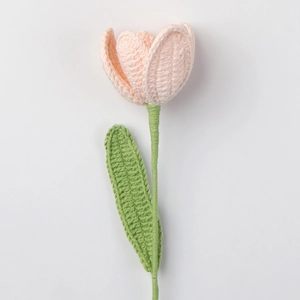 Detaillierte Strickstruktur einer handgefertigten rosa Tulpe Häkelblume auf weißem Grund