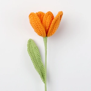 Handgefertigter Häkel-Tulpenstrauß in Orange mit grünen Blättern auf weißem Grund