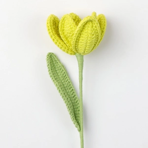 Detail der handgehäkelten Tulpe mit gelben Blütenblättern und grünem Strickstiel