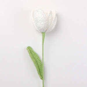 Detail der Strickstruktur einer handgefertigten weißen Tulpe mit Stiel und Blatt