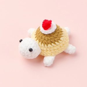 Nahaufnahme der handgefertigten Häkelschildkröte mit weicher Garnstruktur und kleinem Pompon