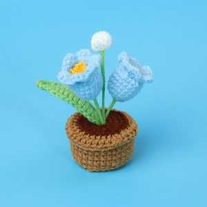 Detailed crochet view of blue lily of the valley and white flower in a yarn pot
