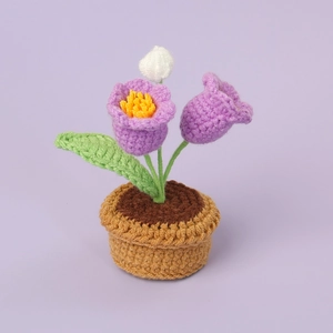 Handmade crochet lily of the valley potted plant with purple flowers on purple background