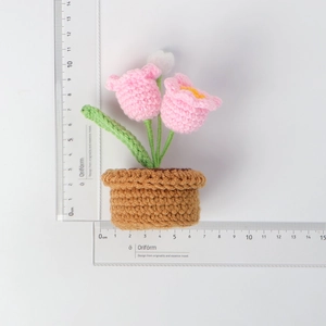Detailed view of handmade crochet flower pot with height measurement shown on scale