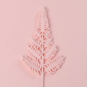 Detailed texture of pink hand-knitted fern leaf decoration on matching pink background