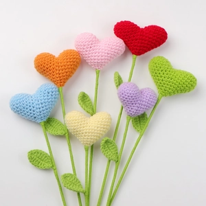 Detail view of seven colorful crochet heart flowers in rainbow shades for gift
