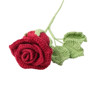Handmade crochet red rose flower bouquet with green leaves on white background