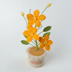 Dettaglio macro di clematide all'uncinetto fatta a mano con fiori arancioni e foglie