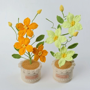 Dettaglio di fiori fatti a mano all'uncinetto con petali arancioni e verdi su base