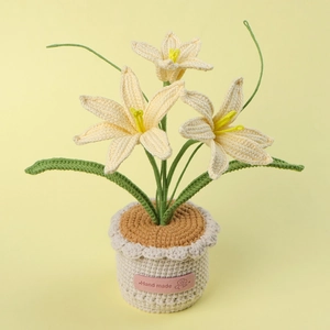 Macro shot of handmade crochet potted lilies with pink Hand Made tag on beige base