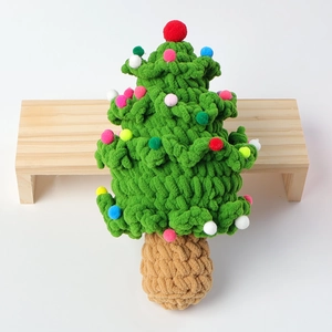 Handmade crochet Christmas tree with colorful pompoms on white background with wood decor