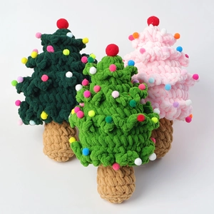 Macro shot of handmade crochet Christmas tree ornaments in green and pink yarn colors