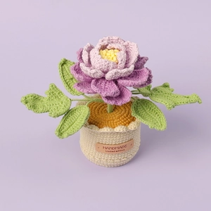 Detail of hand-knitted peony plant in a cream pot with a handmade leather label tag