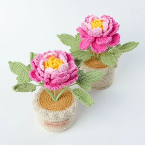Macro detail of hand-crocheted pink peony potted plant with handmade leather label