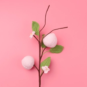 Handmade crochet peach blossom branch with pink knitted peaches and green leaves