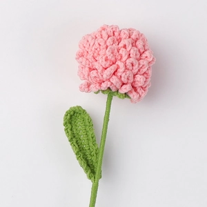 Detailed close-up of handmade pink crochet flower with green stem and leaf textures
