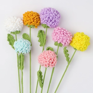 Detailed view of seven colorful handmade crochet chrysanthemum flowers with green stems