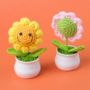 Handmade crochet sunflower and daisy potted plants with cute smiling faces on orange background